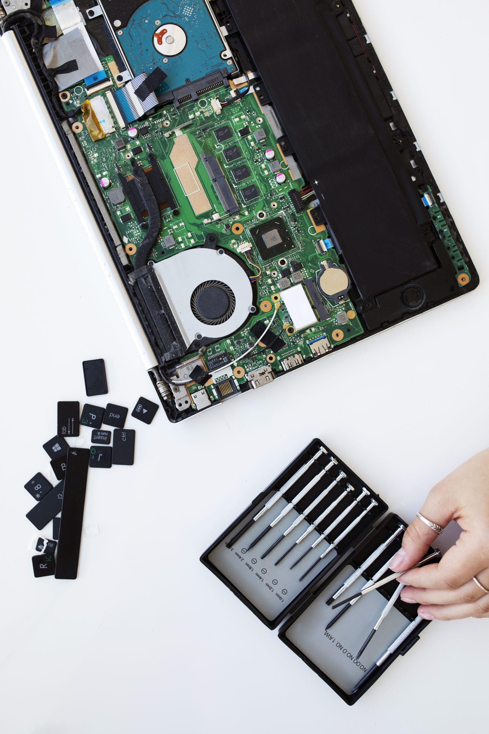mujer joven limpiando el teclado de su computadora portatil